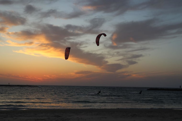 In Tel Aviv, two people kitesurfing shortly after having to run to a shelter after sirens sounded.