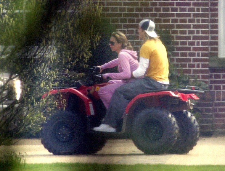 David Beckham (L) and his wife Victoria ride on a quadbike at their Hertfordshire home, 12 April 2004.