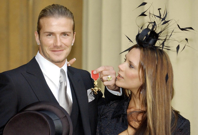 David Beckham stands with his wife, Victoria, as he shows off the OBE (Officer of the Order of the British Empire)  he received 27 November , 2003, from Britain's Queen Elizabeth II at London's Buckingham Palace. The former Manchester United star, who now plays for Real Madrid, said recently: 'I am honoured and privileged to receive this recognition. It's not just for me but for Manchester United, England, all of my teammates and my family'.
