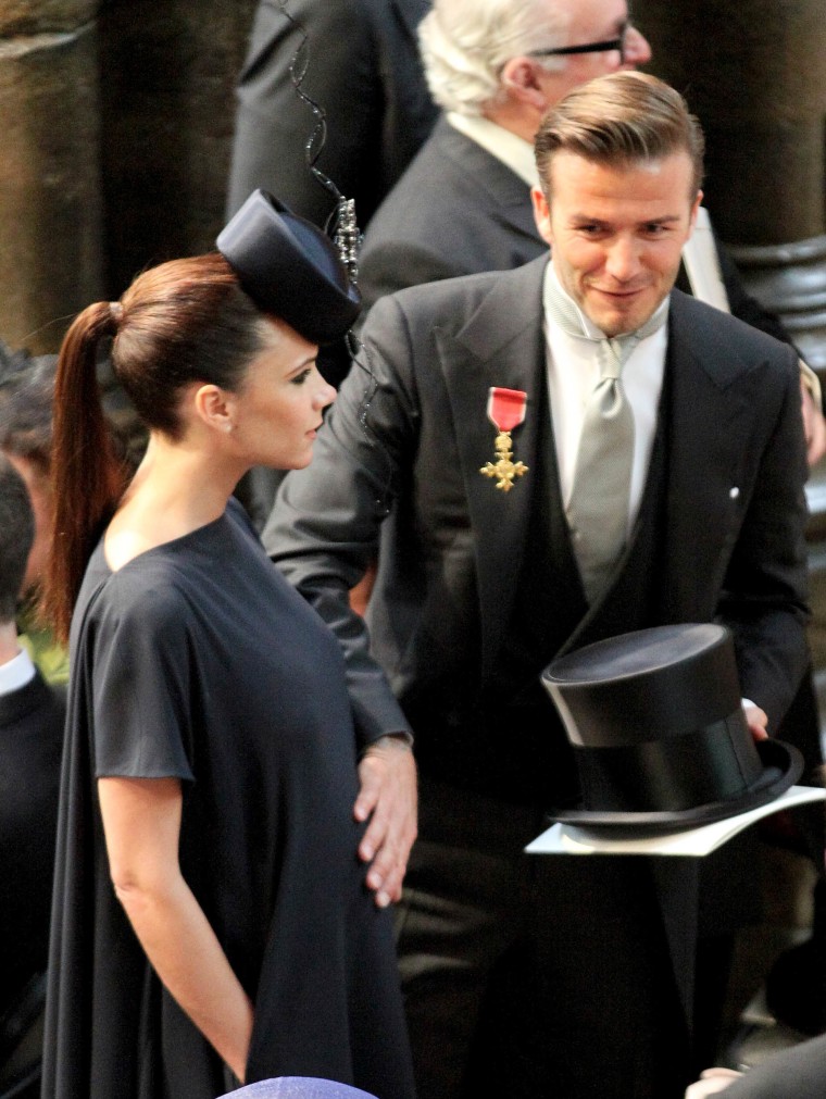 David Beckham pats his wife Victoria's baby bump as they arrive at Westminster Abbey in London, for the royal wedding of Britain's Prince William and Kate Middleton, on April 29, 2011.