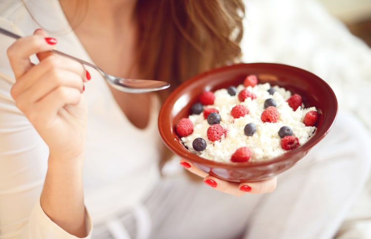 woman eats cottage cheese with berries