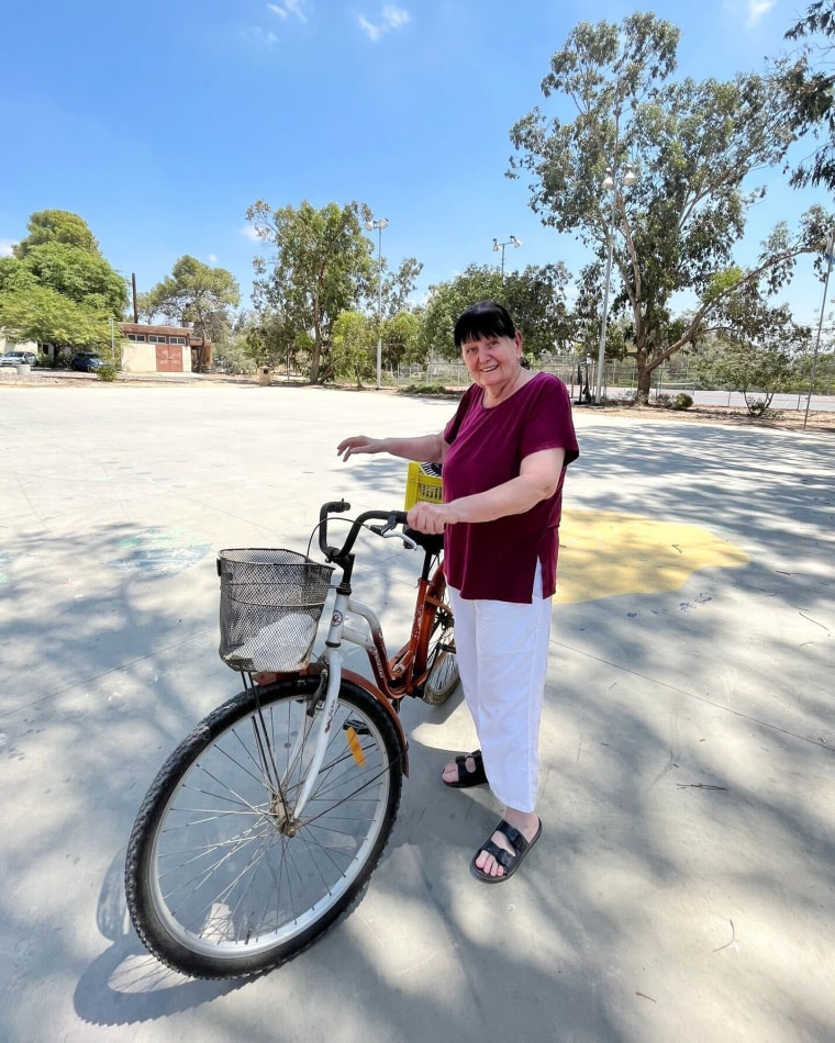 Bracha Levinson poses for a photo by a bicycle.