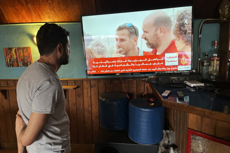 A bartender in Ain Ebel watches the latest events unfolding in Gaza on Al Jazeera.