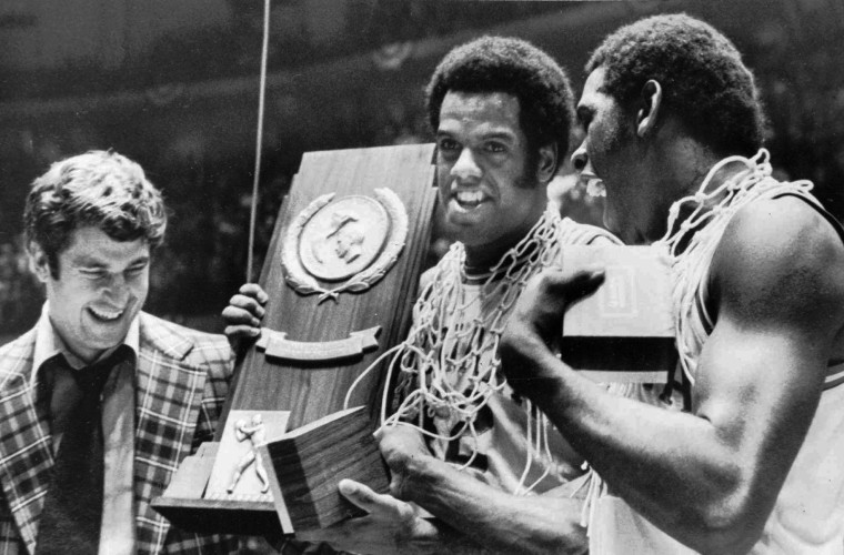 Indiana coach Bobby Knight, left, and team members Scott May, center, and Quinn Buckner smile with the NCAA Basketball championship trophy 