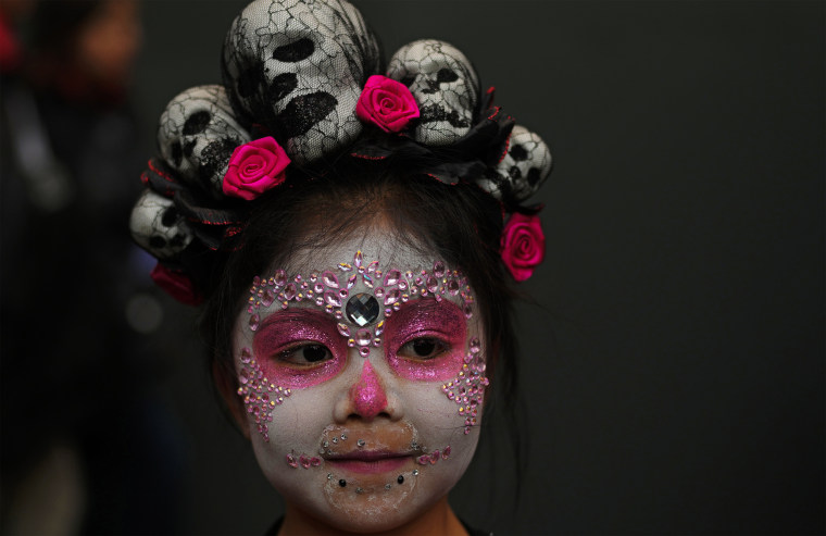 A girl with her face painted as a "Catrina" collects candy during a Day of the Dead celebration in La Paz, Bolivia, on Oct. 31, 2023.