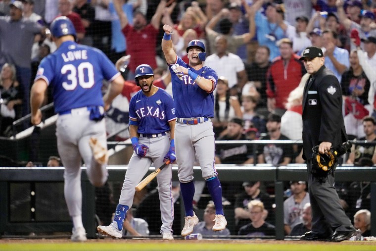 Texas Rangers' Josh Jung and Nathaniel Lowe celebrate after scoring on a single by Jonah Heim during the ninth inning in Game 5 of the baseball World Series against the Arizona Diamondbacks on Nov. 1, 2023, in Phoenix.