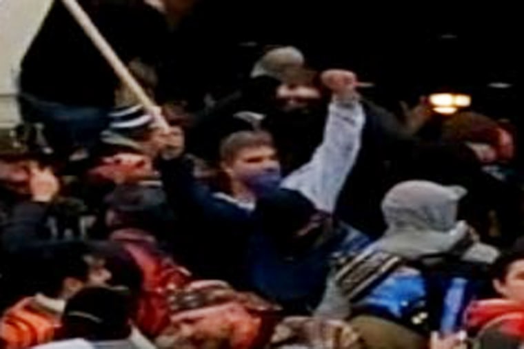 Steven Cappuccio raises a "Thin Blue Line" police flag while rioting at the Capitol