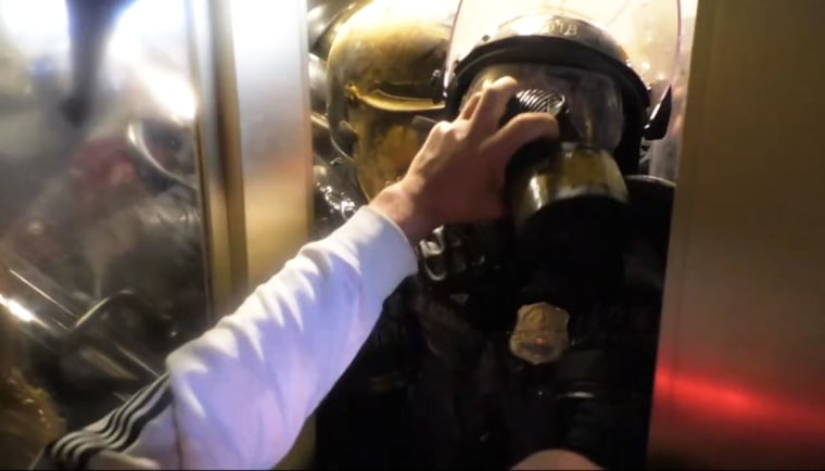 Steven Cappuccio grabs Officer Daniel Hodges mask