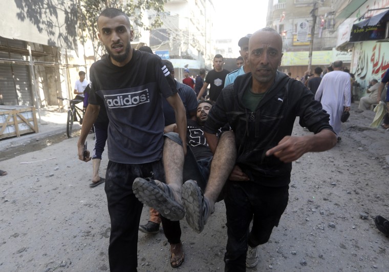 Palestinians evacuate a wounded man following an Israeli airstrike in Bureij refugee camp, Gaza Strip