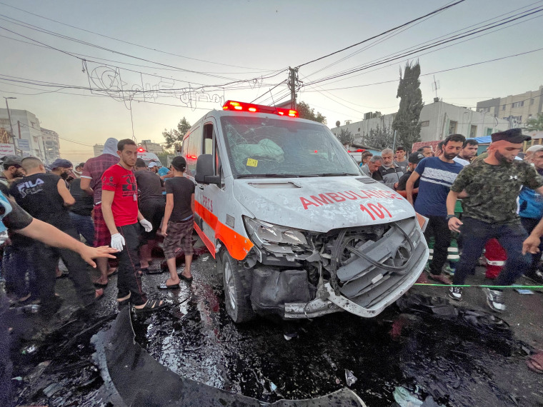 Palestinians check the damages of an ambulance convoy
