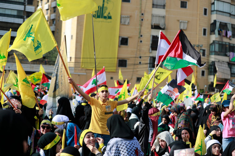 A boy waves the Hezbollah party flag during a rally prior to a speech by the leader of the party in Beirut's southern suburb