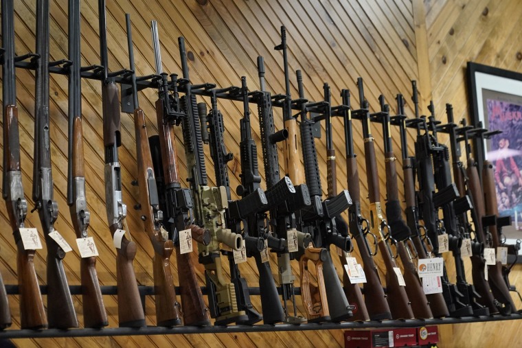 Guns rest in a rack at a gun shop