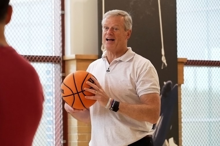 Charlie Baker holds a basketball during an interview on the indoor court