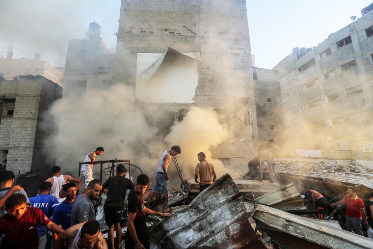 People search through buildings that were destroyed during Israeli air raids