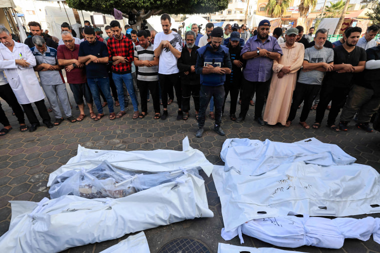 People pray near those killed in an Israeli strike on the Al-Maghazi refugee camp in Deir al-Balah, Gaza.