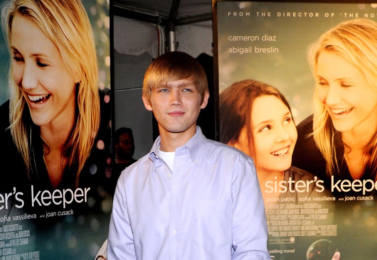 Evan Ellingson smiles infront of posters of "My Sister's Keeper" at the premiere.