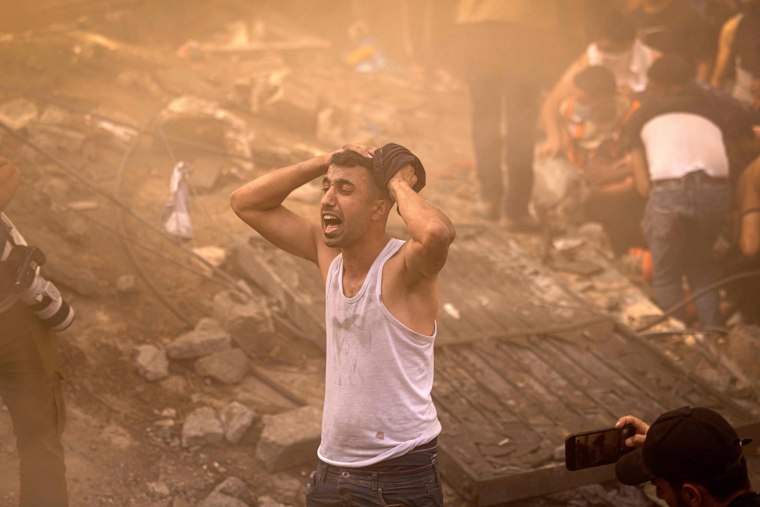 A Palestinian man reacts as others check the rubble of a building in Khan Yunis, Gaza, on Nov. 6, 2023.