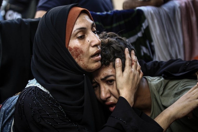 A Palestinian woman consoles a child following Israeli airstrikes on the al-Fakhoora district of Jabaliya in northern Gaza, on Nov. 4, 2023. 