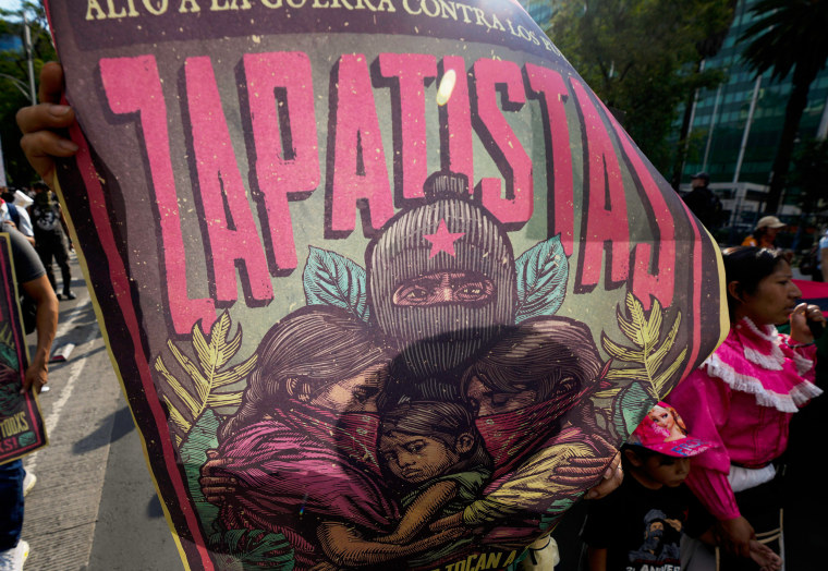 A supporter of the Zapatista Army of National Liberation, EZLN, holds up a poster in Mexico City.