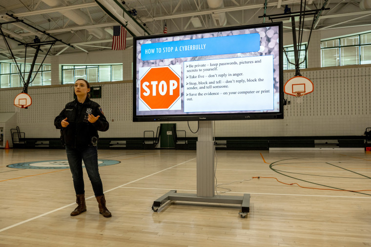 Police teach eighth graders about internet safety and cyberbullying at a middle school event