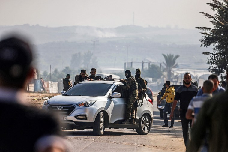 Palestinian fighters from the Izz al-Din al-Qassam Brigades advance towards the Erez crossing between Israel and the northern Gaza Strip.