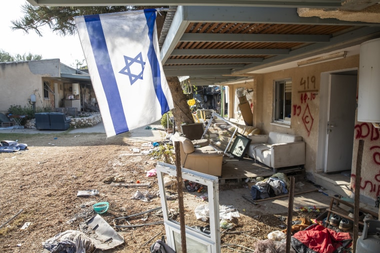 KAn Israeli flag hands amid the charred and destroyed buildings of kibbutz kfar aza on Nov. 5, 2023.