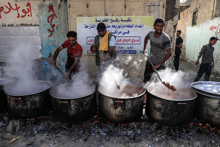 People prepare food at a makeshift charity kitchen to distribute to families in Rafah in the southern Gaza Strip.