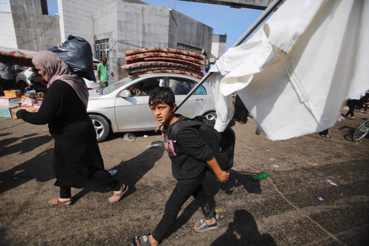 Palestinians carry white flags through Gaza City 