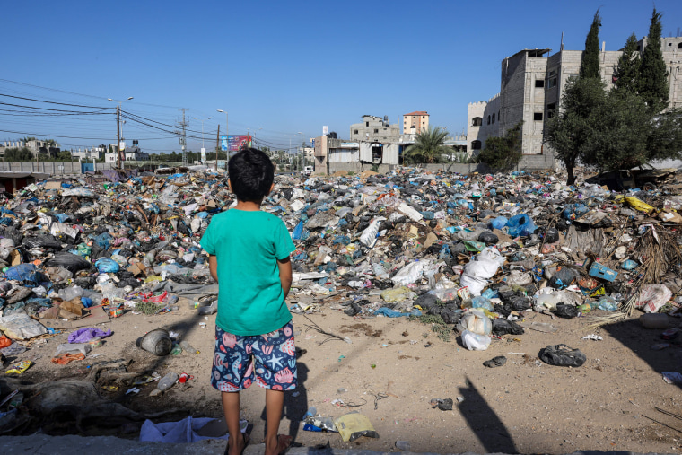 A boy looks at piles of garbage in the Bureij refugge camp in the central Gaza Strip on Nov. 4, 2023.