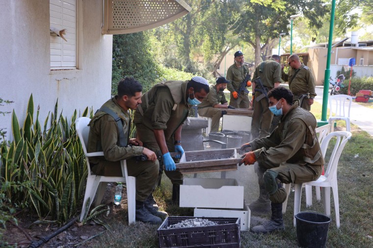 Israeli soldiers help archaeologists from the Israel Antiquities Authority sift through ashes from burned dwellings at the Nir Oz kibbutz in southern Israel on Nov. 9, 2023, to identify residents who went missing after the Oct. 7 attack my Hamas militants. More than 20 people were reported killed and at least 75 were taken hostage from Nir Oz.