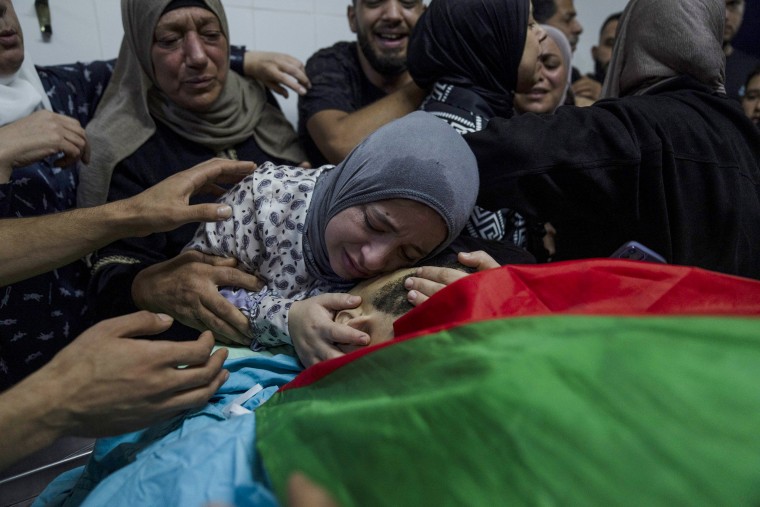 Alaa Jadelhaq embraces her husband, Mohanad Jadelhaq, for the last time during his funeral in the West Bank city of Ramallah.