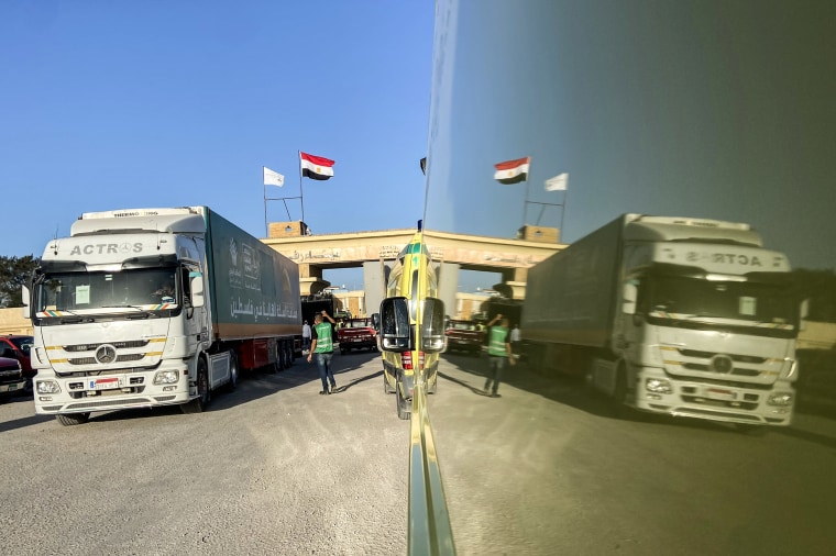 Aid convoy trucks cross back into Egypt after offloading aid in Gaza.