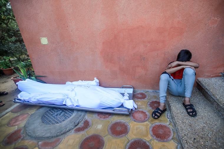 A childfamily cries next to the bodies of his father and two brothers at the al-Nasser hospital in Khan Yunis in the southern Gaza Strip.