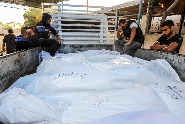 People mourn over the bodies of their relatives as they're taken from the morgue of An-Najjar Hospital to their funeral in Rafah, Gaza.