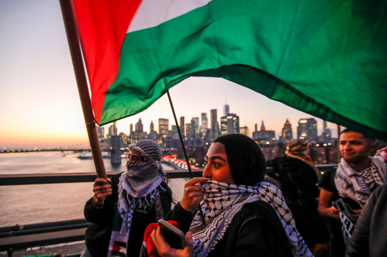Demonstrators hold Palestinian flags as they walk over the Brooklyn Bridge during a rally in support of Palestinians in New York.