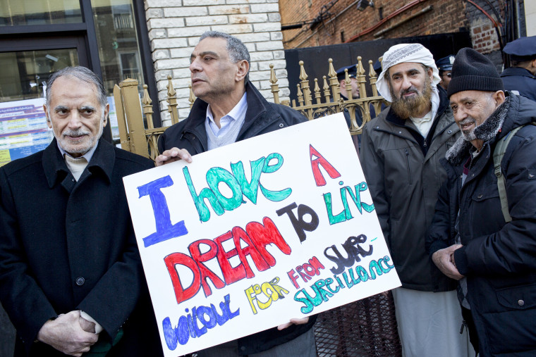 A man holds a sign that reads "I have a dream to live without fear from surveillance" during a Martin Luther King Day march against Islamophobia.