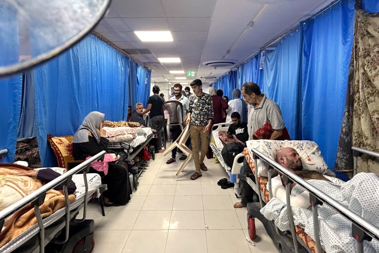A hospital hallway is lined with injured patients and internally displaced people