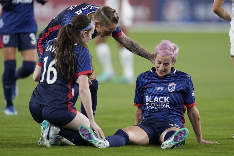 OL Reign forward Megan Rapinoe, right, stays down after an injury as teammates Rose Lavelle, left, and Jess Fishlock, center, check on her during the first half of the NWSL Championship soccer game against Gotham FC, Saturday, Nov. 11, 2023, in San Diego. 