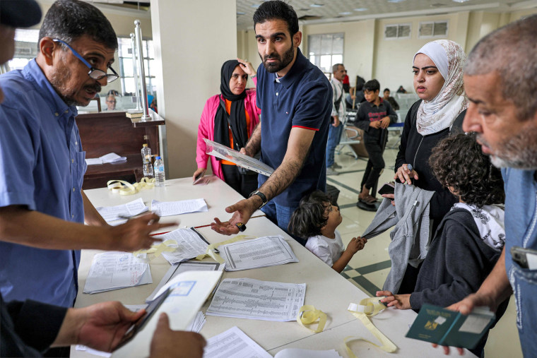 People present their travel documents to be checked on the Palestinian side of the Rafah border crossing with Egypt in the southern Gaza Strip on Nov. 12, 2023.