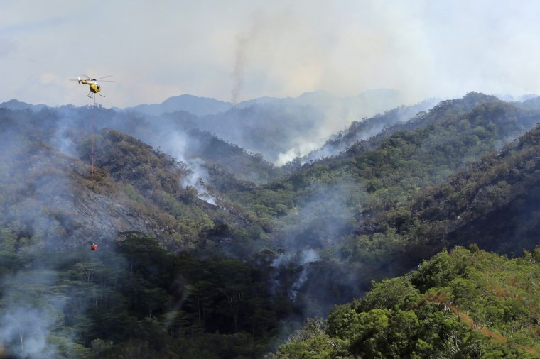 An Army helicopter douses a wildfire burning east of Mililani, Oahu, Hawaii, on Thursday, Nov. 2, 2023. 