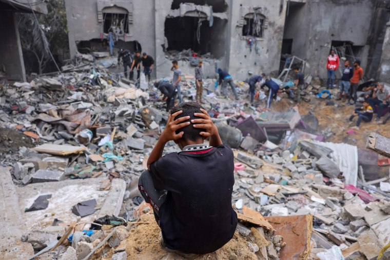A child reacts as people salvage belongings amid the rubble of a damaged building following strikes on Rafah in the southern Gaza Strip, on Nov. 12, 2023.