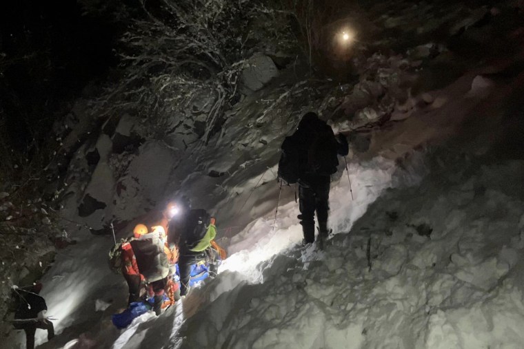 The search and rescue team descends with a distressed hiker.