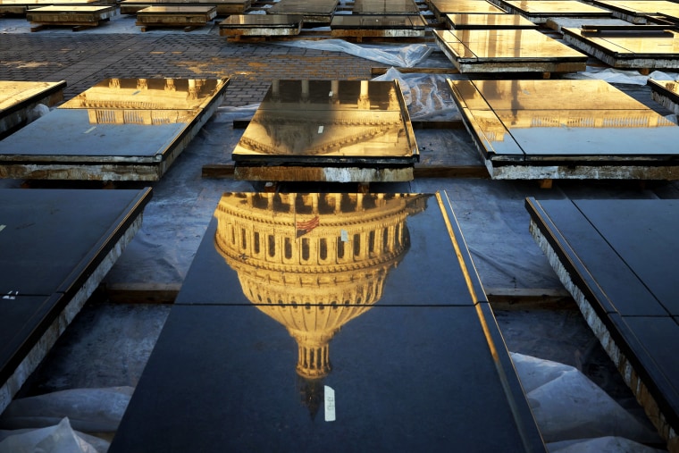Sunrise hits the U.S. Capitol dome as it is reflected in marble panels