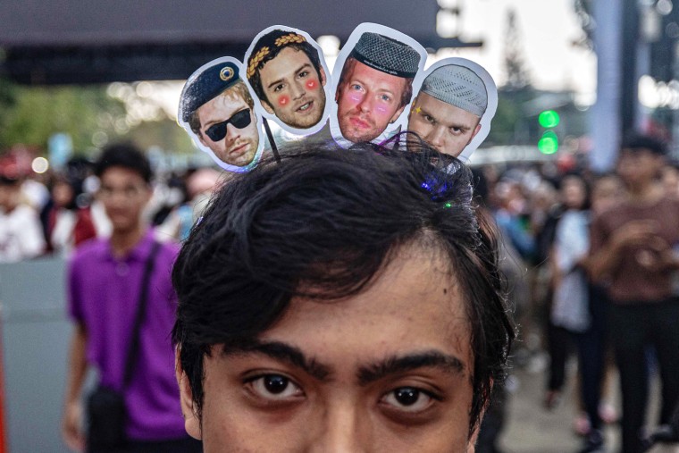 A Coldplay member wears a headband with images of the band before a concert in Jakarta on November 15, 2023.