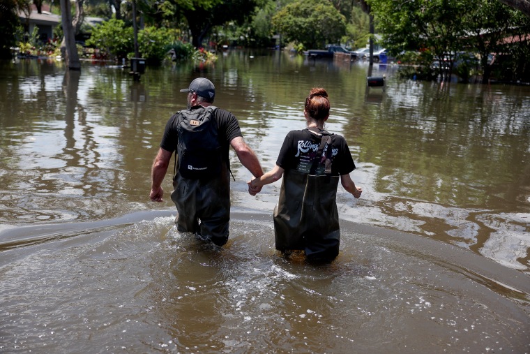 People trudge through floodwater toward their home in Fort Lauderdale.
