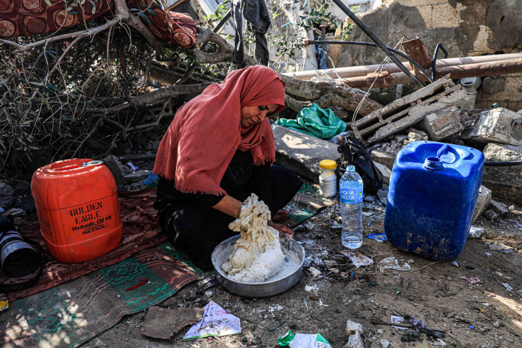 A woman mixes flour with water to make bread in Rafah, southern Gaza.