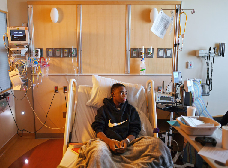 Issac Martin sits up in a hospital bed