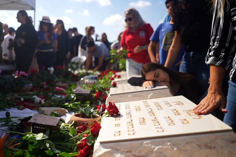 People leave rocks, flowers and prayers at headstones of the Kutz family in Ashdod today.