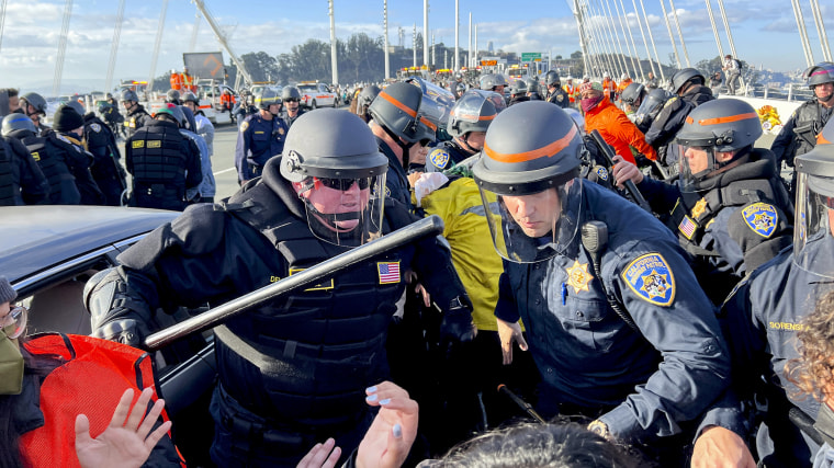 Police officers clear protesters blocking the San Francisco-Oakland Bay Bridge while demonstrating against the APEC summit.