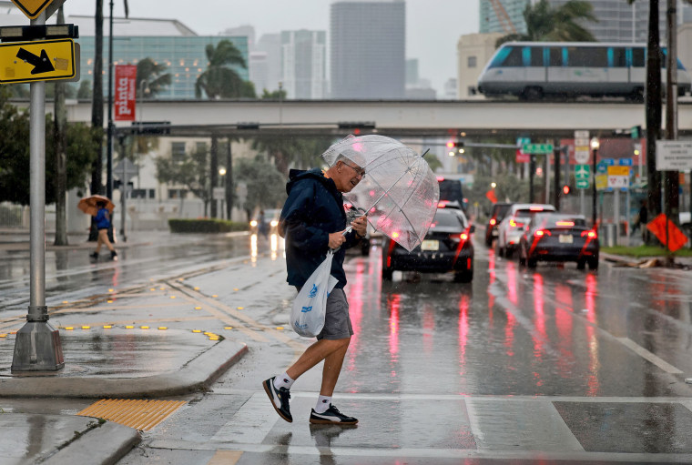 A pedestrian crosses the street in a rain storm on Nov. 15, 2023 in Miami.